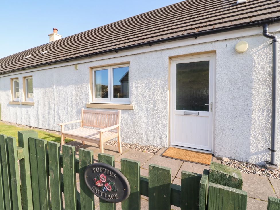 An entrance with a bench and a door at Poppies Cottage in Craignure, Isle Of Mull
