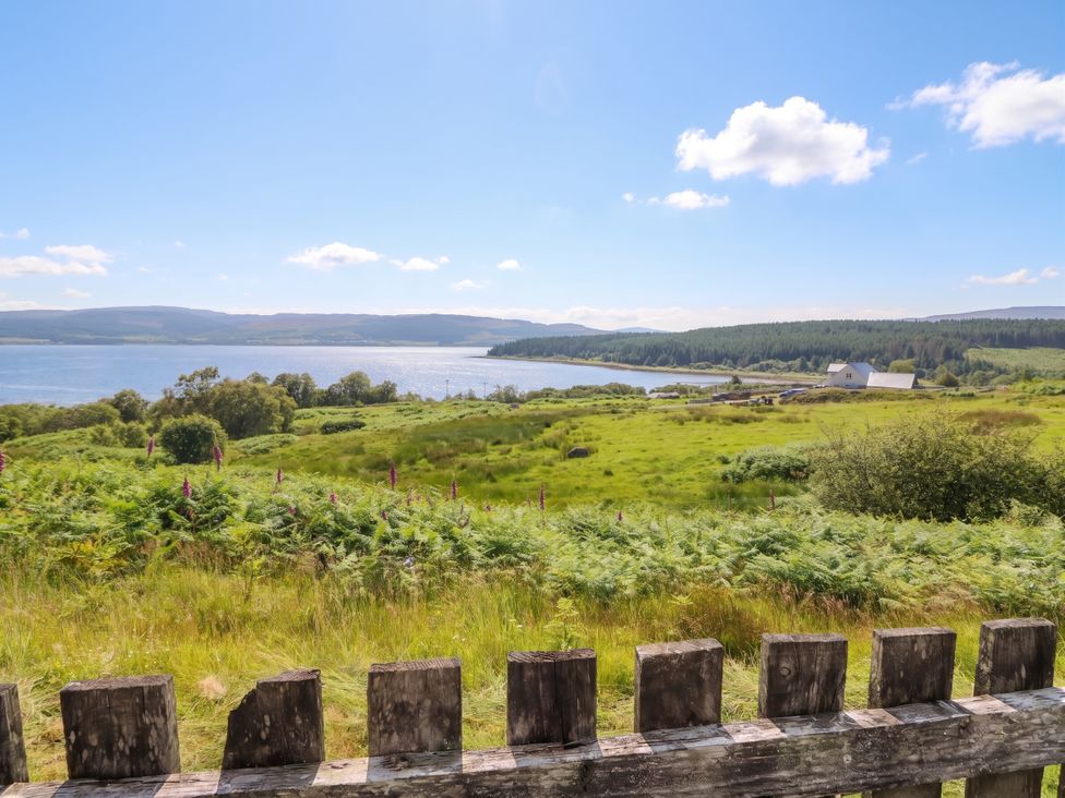 A view of water and greenery with a fence at Poppies Cottage Craignure, Isle Of Mull