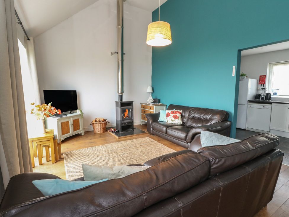 A living room with a sofa and a television at Poppies Cottage, Craignure, Isle Of Mull