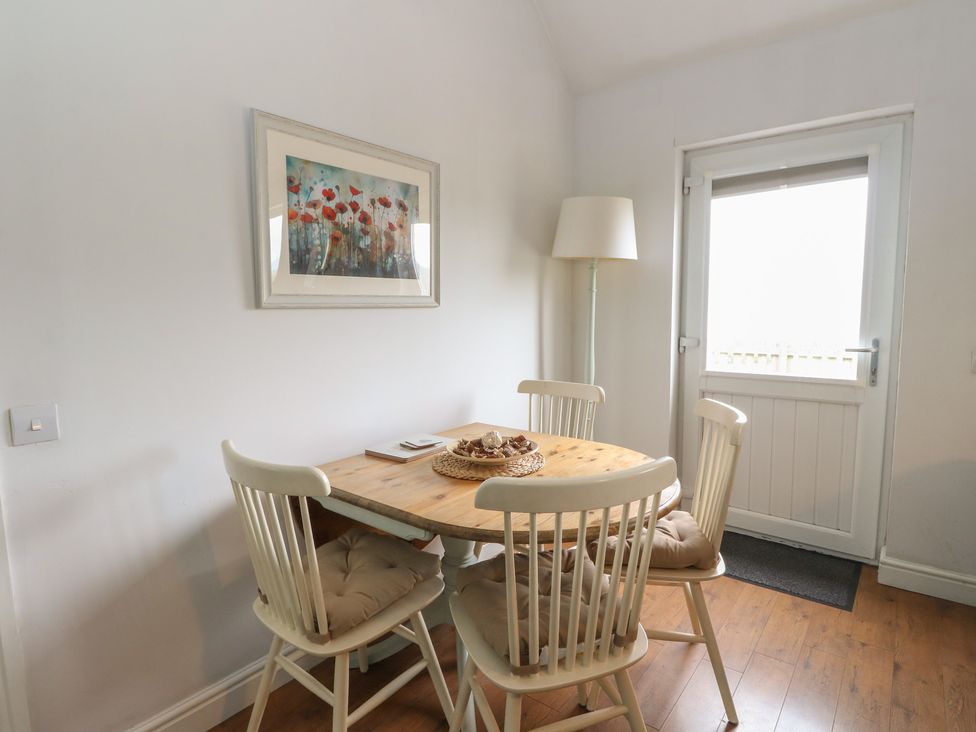 A dining room with a table and chairs at Poppies Cottage, Craignure, Isle Of Mull