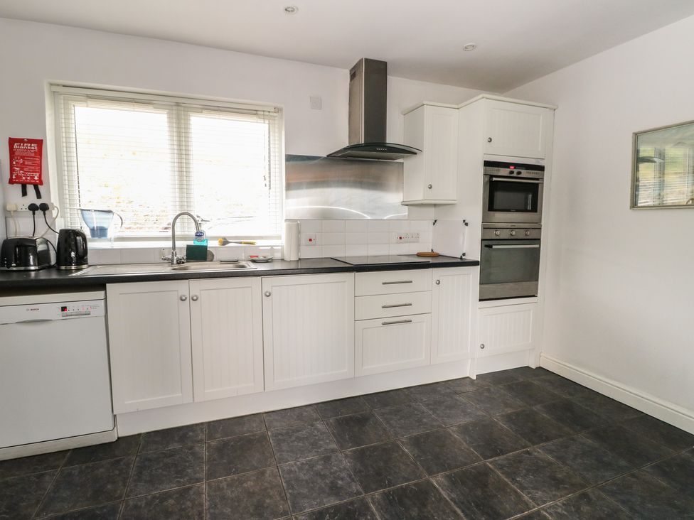 A kitchen with cabinets and appliances at Poppies Cottage, Craignure, Isle Of Mull