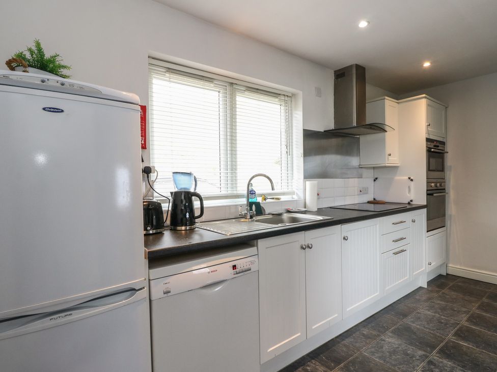 A kitchen with a refrigerator, sink, and appliances at Poppies Cottage Craignure, Isle Of Mull