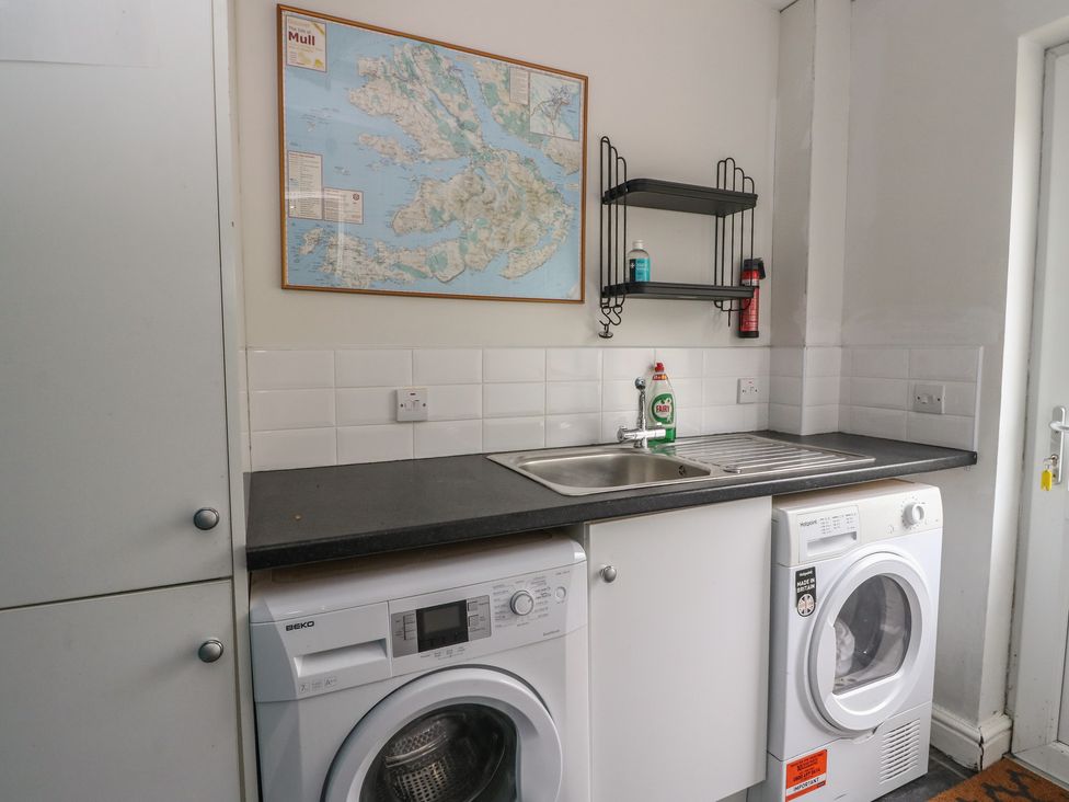 A laundry room with a washing machine and tumble dryer at Poppies Cottage, Craignure, Isle Of Mull