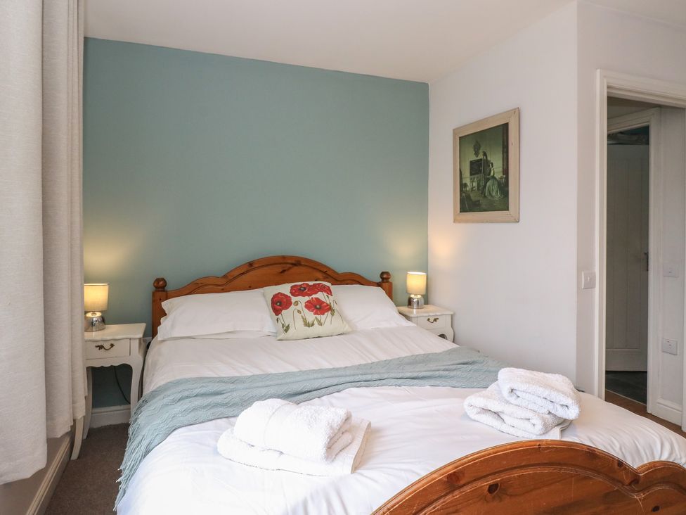 A bedroom with a bed and bedside tables at Poppies Cottage in Craignure, Isle Of Mull