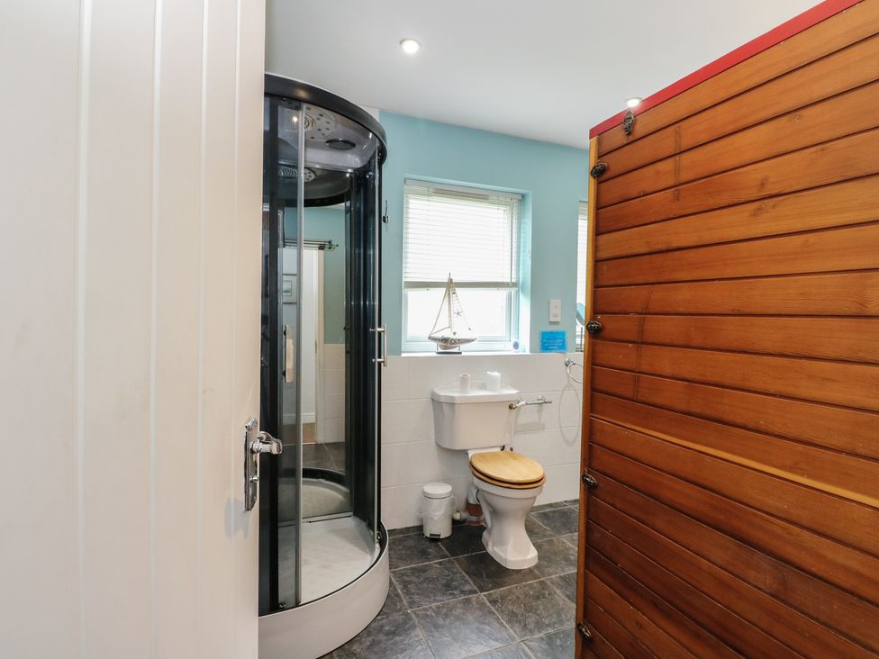 A bathroom with a shower, toilet, and sink at Poppies Cottage in Craignure, Isle Of Mull