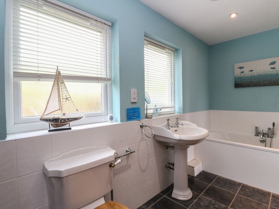 A bathroom with a sink and bathtub at Poppies Cottage, Craignure, Isle Of Mull