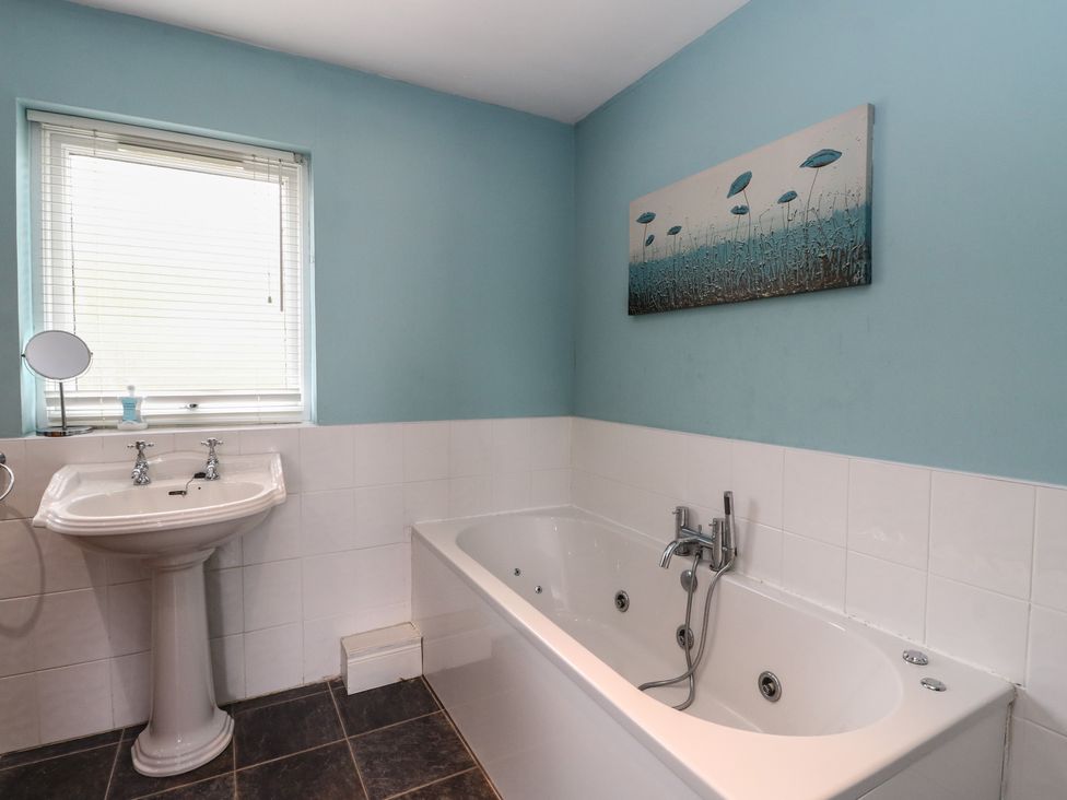 A bathroom with a bathtub and sink at Poppies Cottage Craignure Isle Of Mull