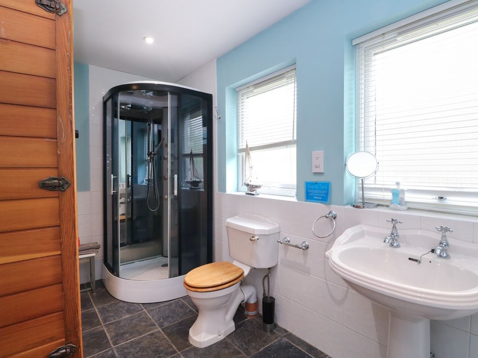 A bathroom with a shower, toilet, and sink at Poppies Cottage in Craignure, Isle Of Mull