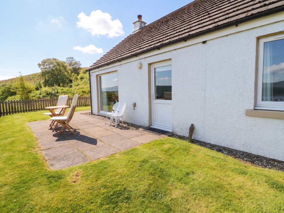 An outdoor patio area with chairs at Poppies Cottage in Craignure, Isle Of Mull