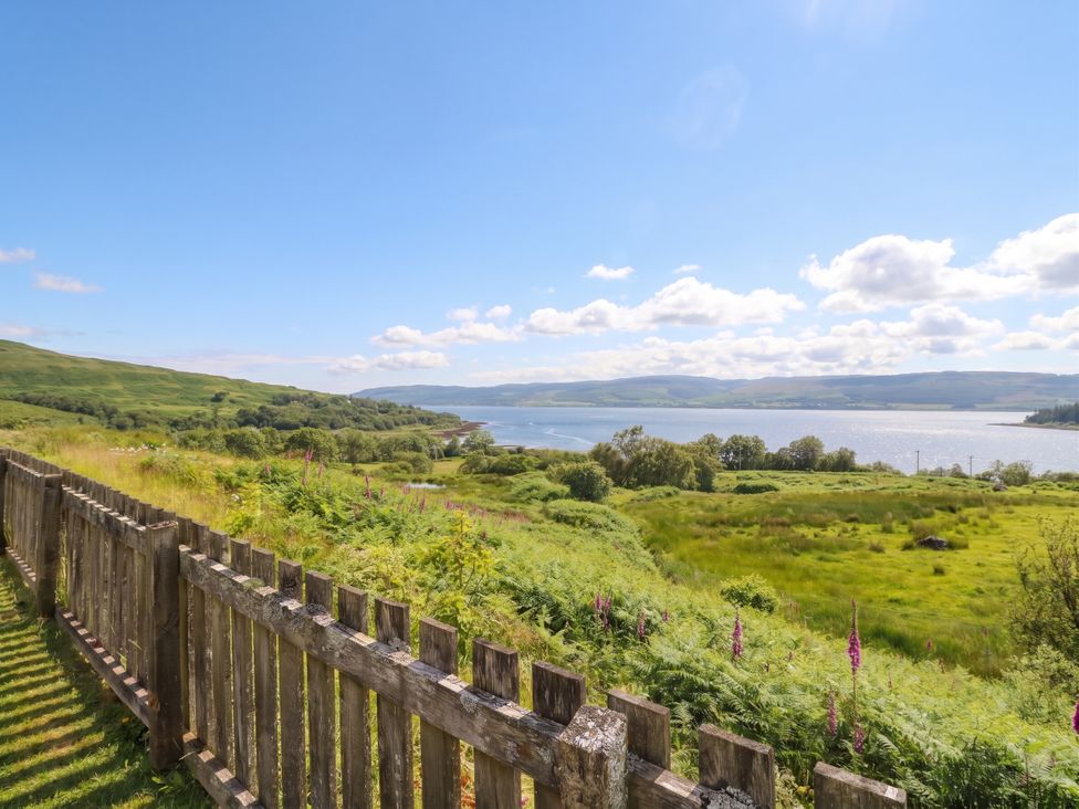 A view of water and landscape with a wooden fence at Poppies Cottage Craignure Isle Of Mull