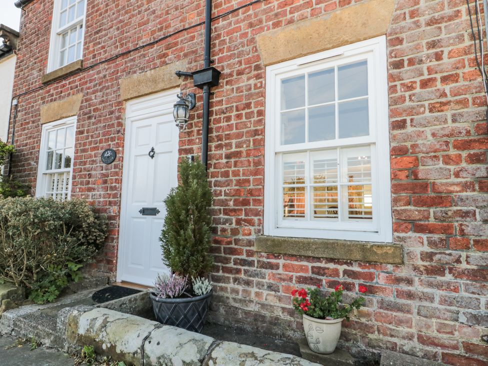 An outdoor view of a brick exterior with a door and windows at Croft View in Fylingthorpe near Robin Hood's Bay