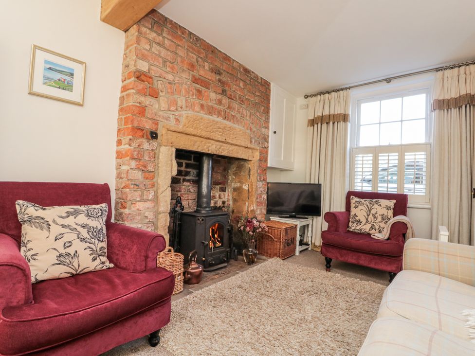 A living room with a fireplace and a sofa at Croft View Fylingthorpe near Robin Hood's Bay