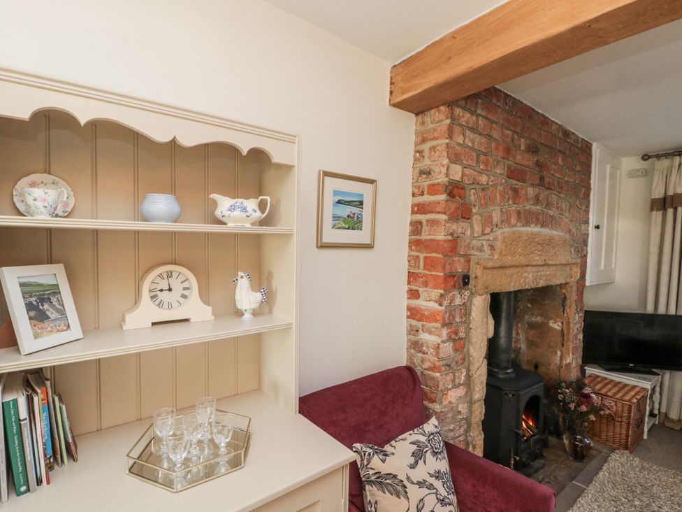 A living room with a shelf and fireplace at Croft View in Fylingthorpe near Robin Hood's Bay
