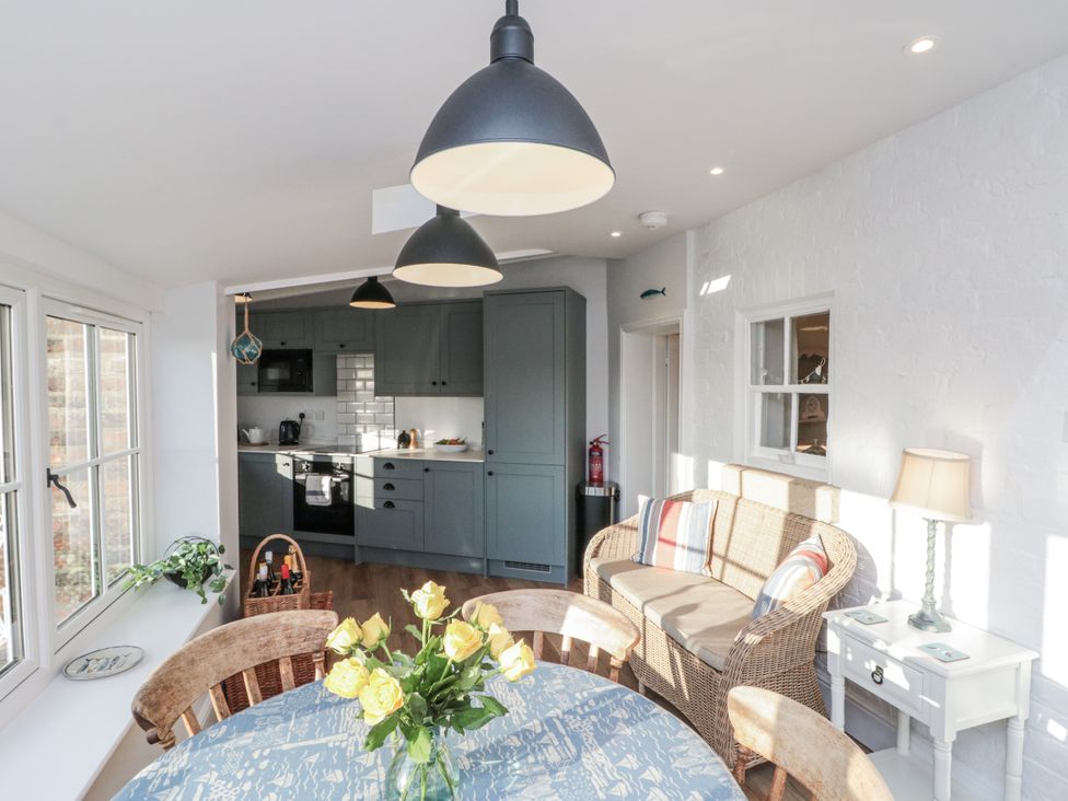 A dining room with a table and flowers at Croft View near Fylingthorpe Robin Hood's Bay