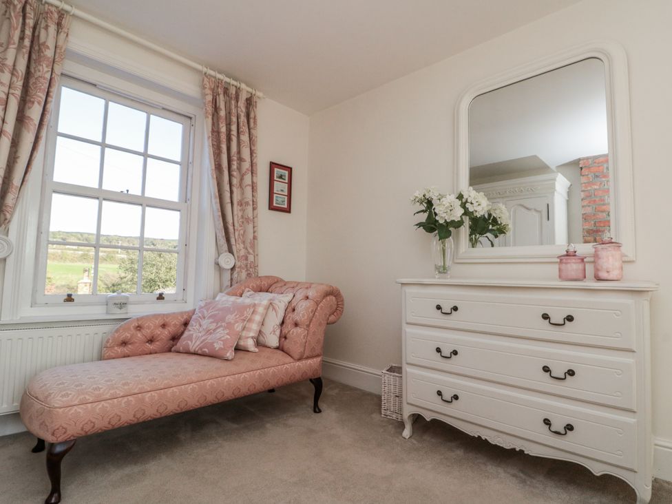 A bedroom with a chaise lounge and a dresser at Croft View in Fylingthorpe near Robin Hood's Bay