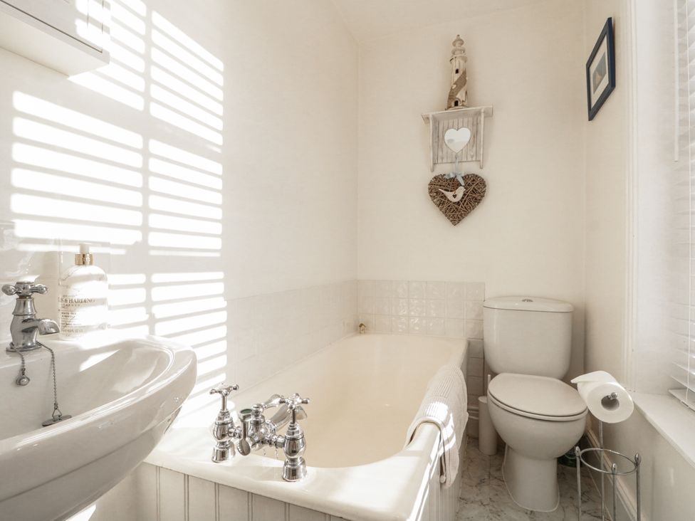 A bathroom with a bathtub, toilet, and sink at Croft View in Fylingthorpe near Robin Hood's Bay