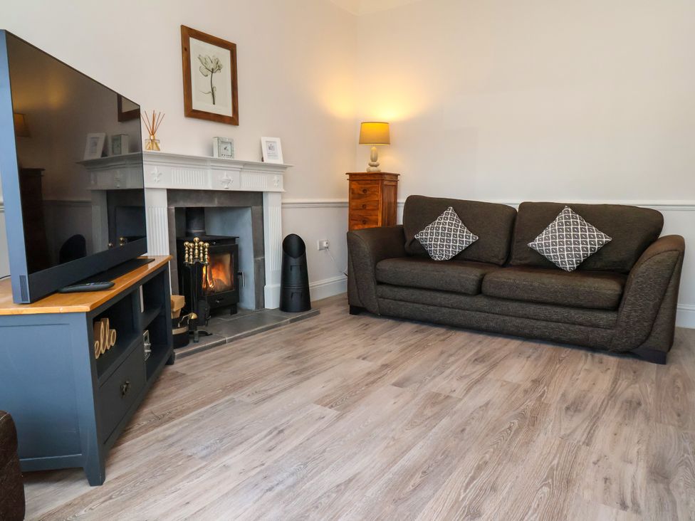 A living room with a sofa and television at 1 Roxby Terrace in Thornton-le-Dale