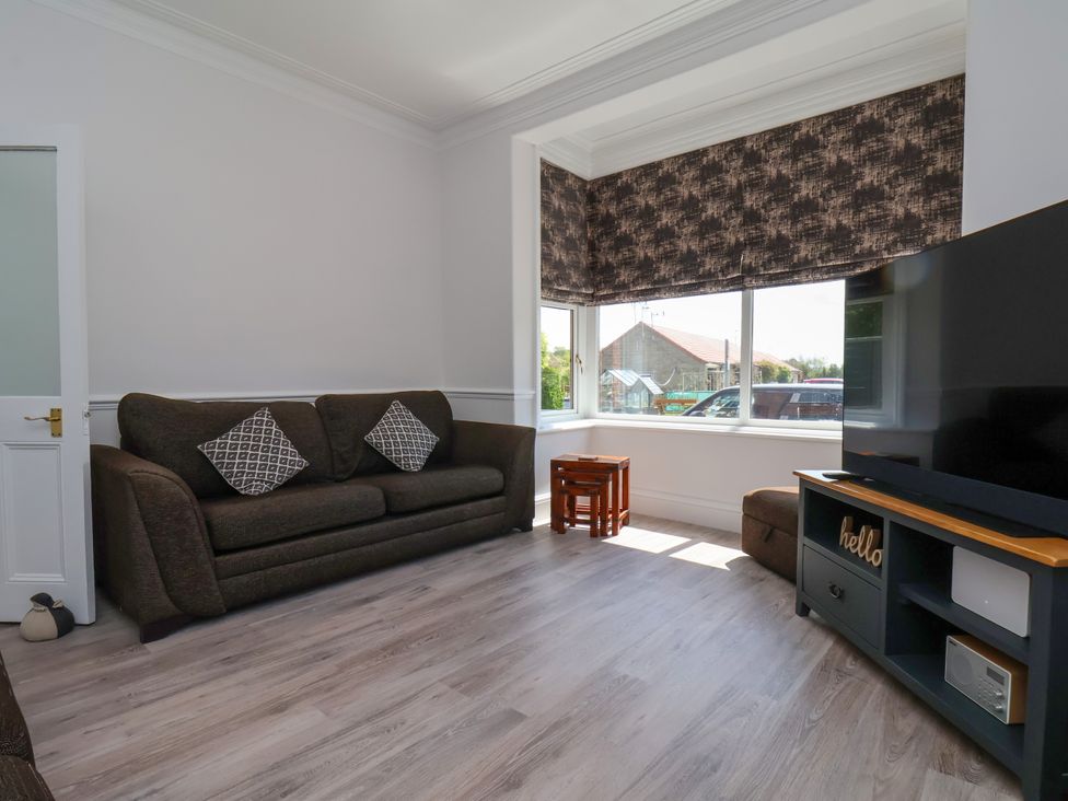 A living room with a sofa and television at 1 Roxby Terrace in Thornton-le-Dale