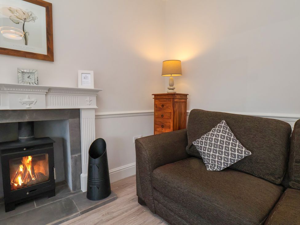 A living room with a sofa and fireplace at 1 Roxby Terrace in Thornton-le-Dale