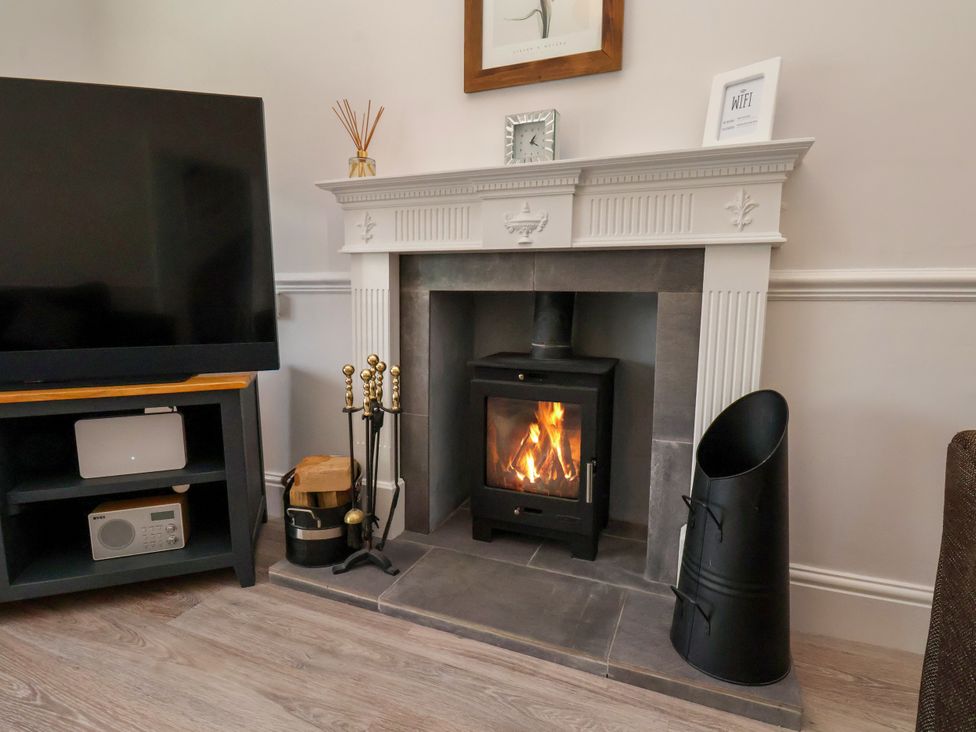 A living room with a fireplace and television at 1 Roxby Terrace in Thornton-le-Dale