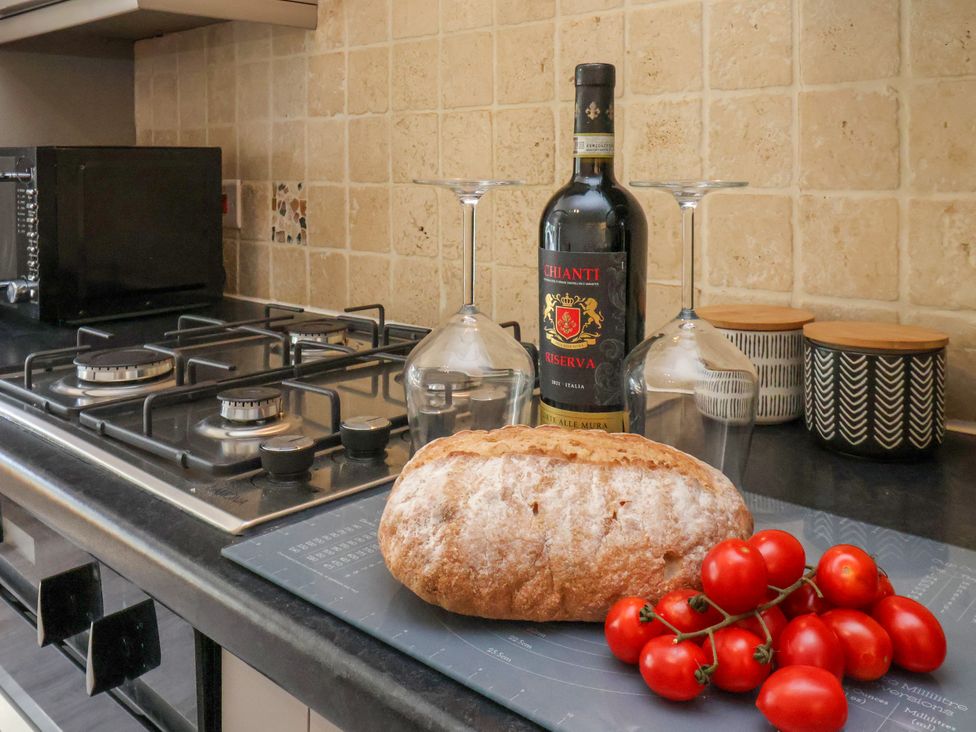 A kitchen with bread, wine and glasses on a countertop at 1 Roxby Terrace, Thornton-le-Dale