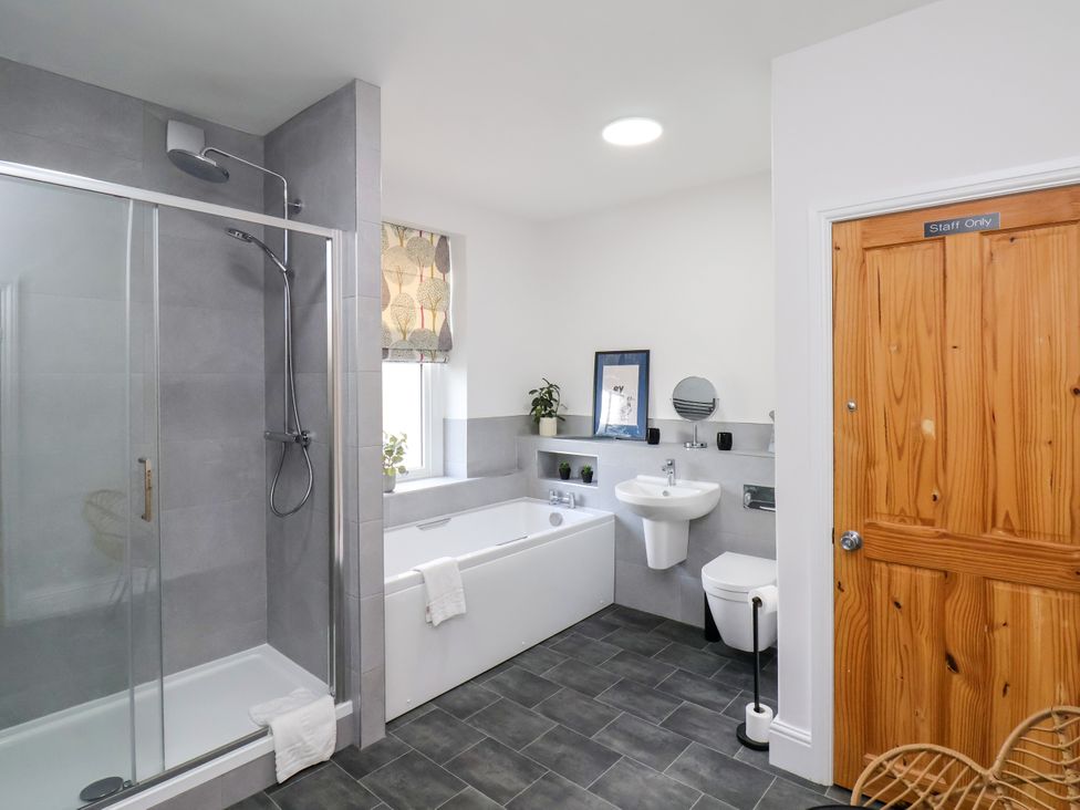 A bathroom with a shower, bathtub and sink at 1 Roxby Terrace Thornton-le-Dale