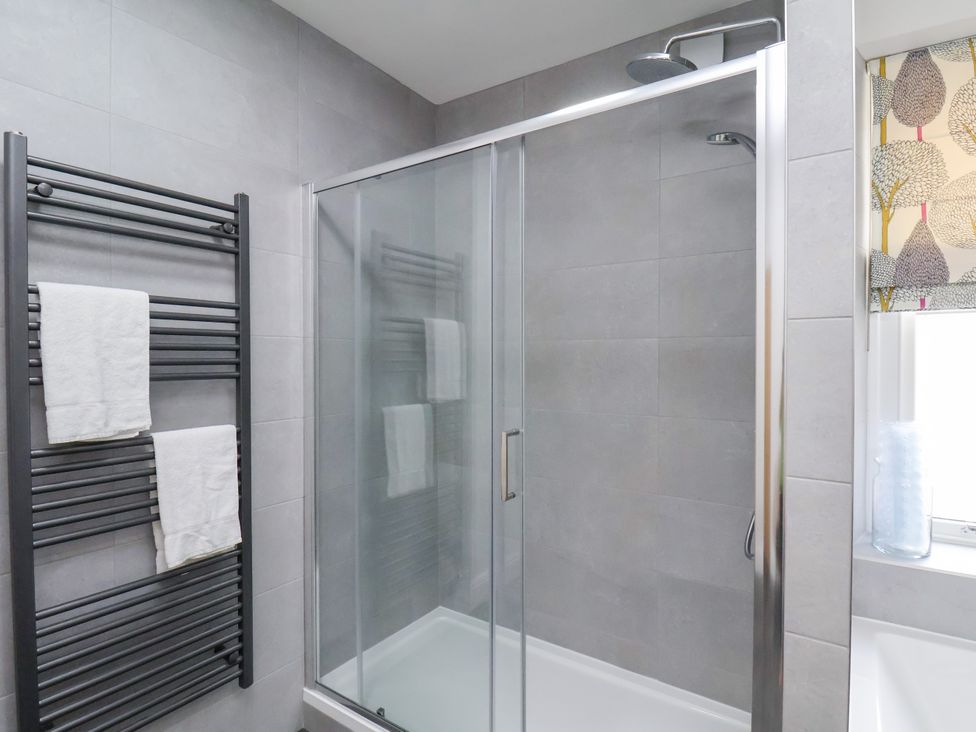 A bathroom with a shower and towel rack at 1 Roxby Terrace Thornton-le-Dale