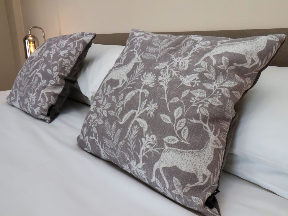A bed with patterned pillows at 1 Roxby Terrace Thornton-le-Dale
