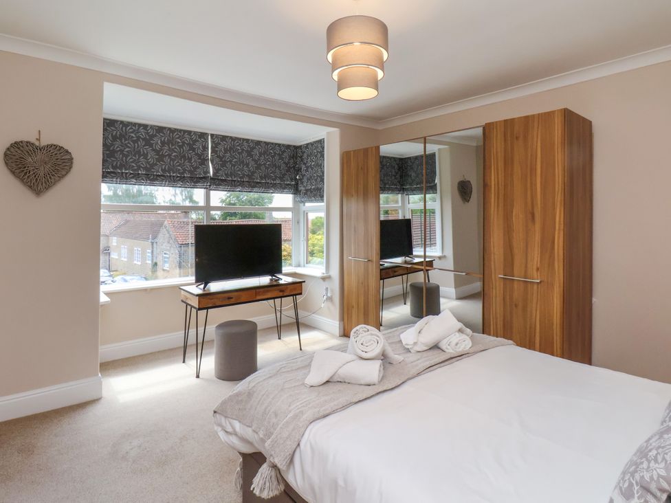 A bedroom with a bed and wardrobe at 1 Roxby Terrace in Thornton-le-Dale