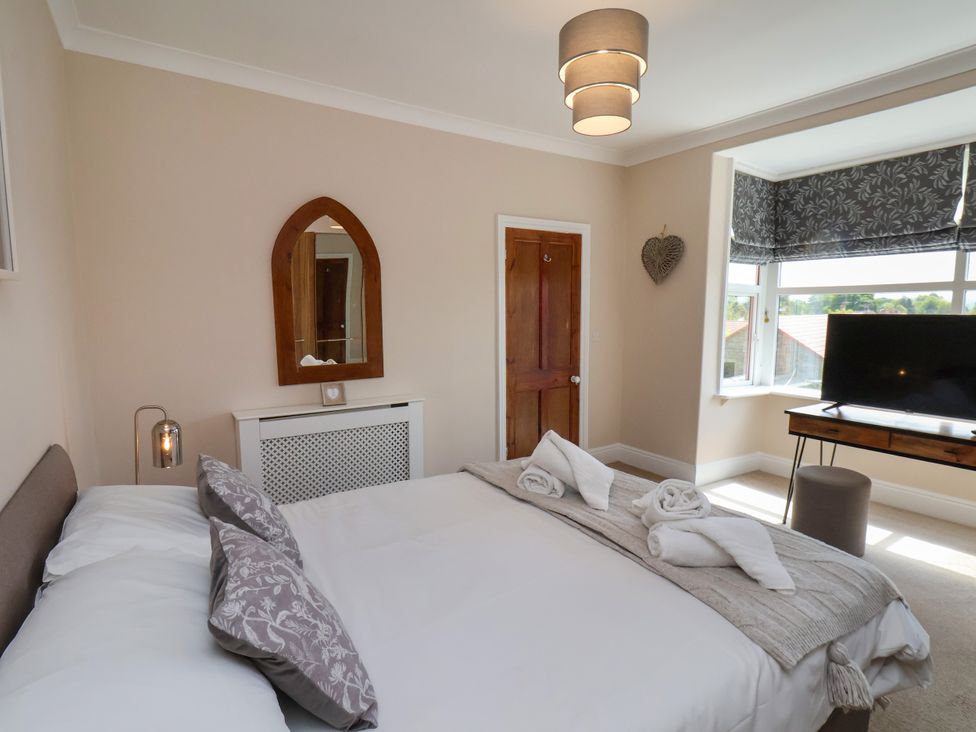 A bedroom with a bed and television at 1 Roxby Terrace in Thornton-le-Dale