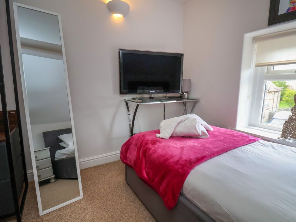 A bedroom with a television and a mirror at 1 Roxby Terrace in Thornton-le-Dale