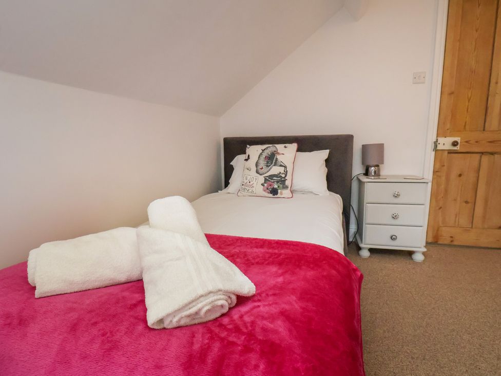 A bedroom with a bed and nightstand at 1 Roxby Terrace in Thornton-le-Dale