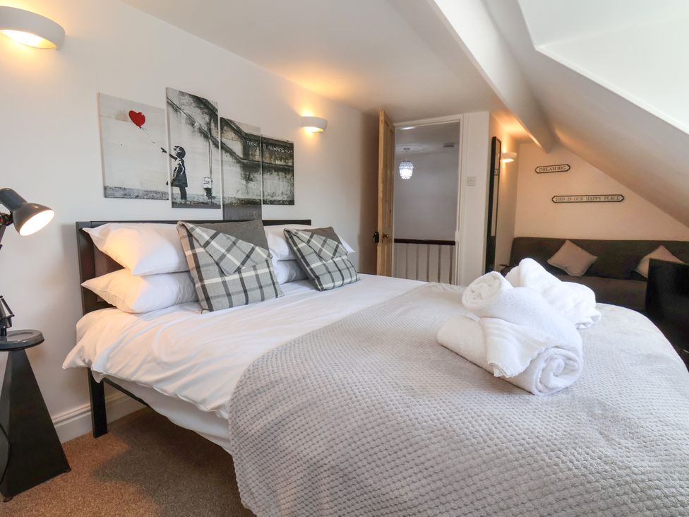 A bedroom with a bed and seating area at 1 Roxby Terrace in Thornton-le-Dale