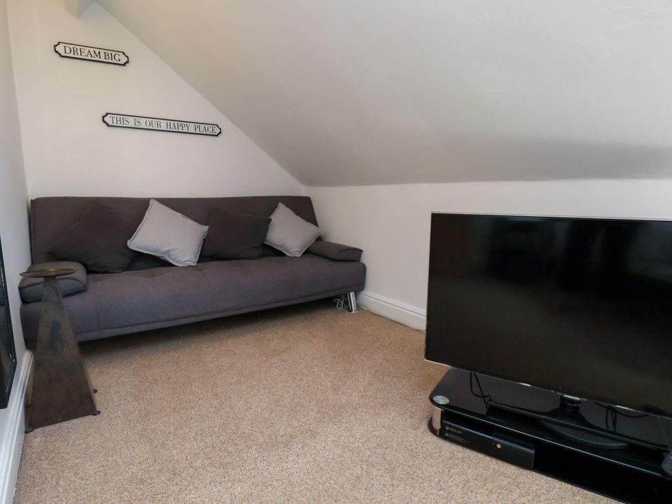 A snug area with a sofa and a TV at 1 Roxby Terrace in Thornton-le-Dale