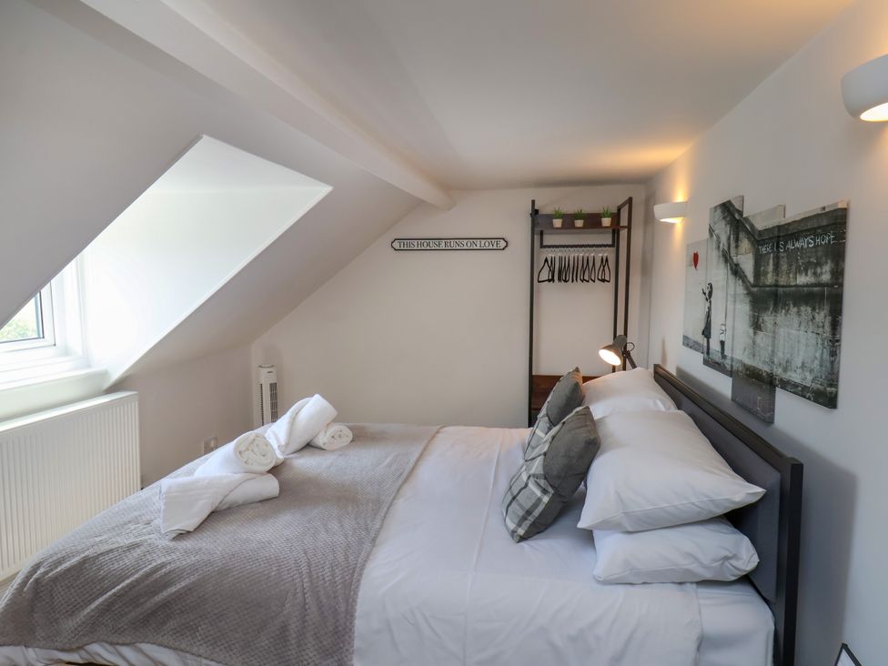 A bedroom with a bed and clothes rack at 1 Roxby Terrace in Thornton-le-Dale
