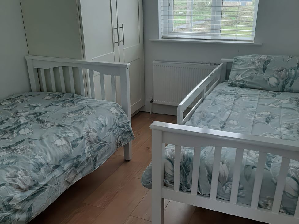 A bedroom with two beds and a wardrobe at 63 Moinin, Kilkee, County Clare