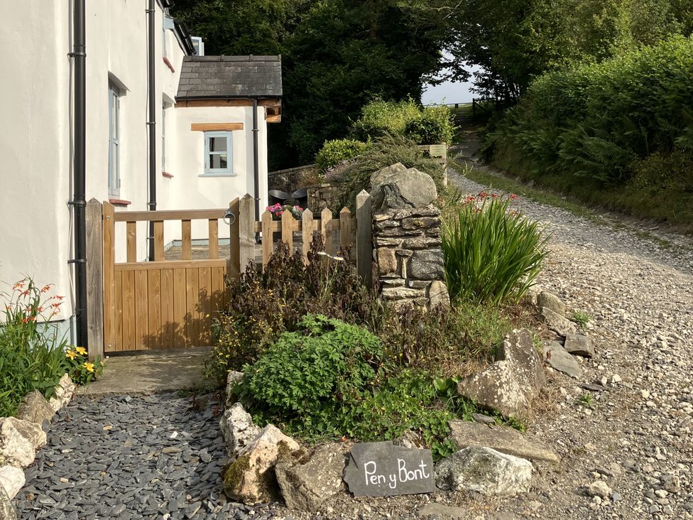A garden entrance with a gate and stone wall at Pen Y Bont in Glyn Ceiriog
