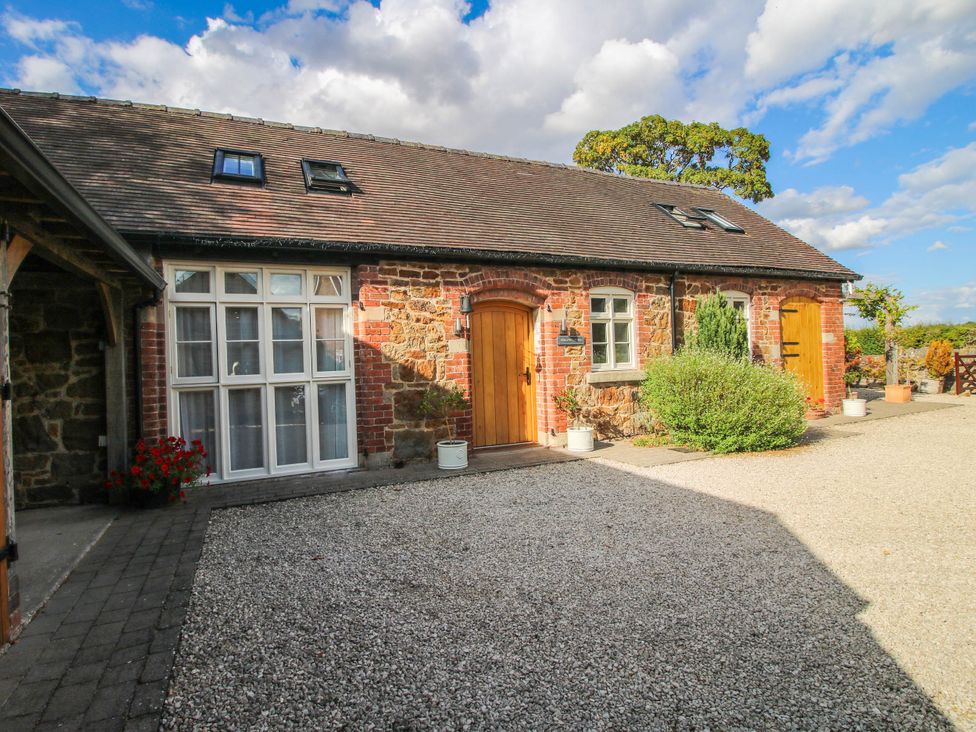 An exterior view of a building with windows and gravel at Swallows Cottage Harley near Much Wenlock