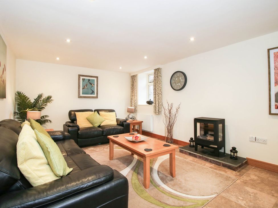 A living room with a sofa and coffee table at Swallows Cottage in Harley near Much Wenlock