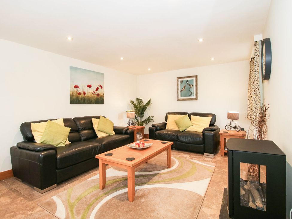 A living room with sofas and a coffee table at Swallows Cottage in Harley near Much Wenlock