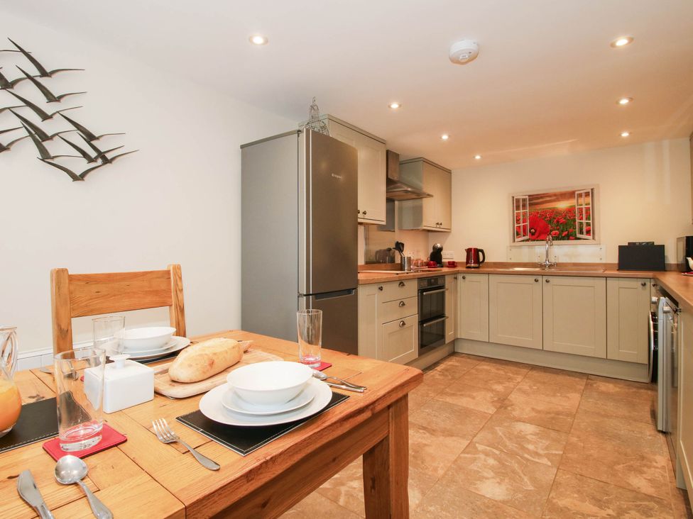 A kitchen with dining table and appliances at Swallows Cottage Harley near Much Wenlock
