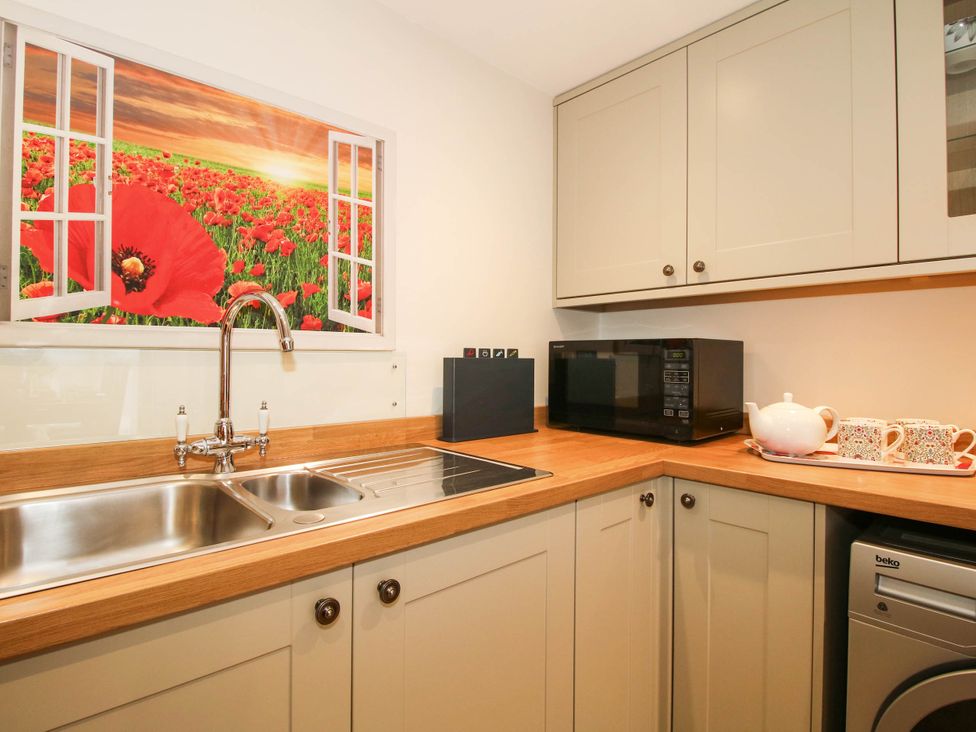 A kitchen with a sink and microwave at Swallows Cottage in Harley near Much Wenlock