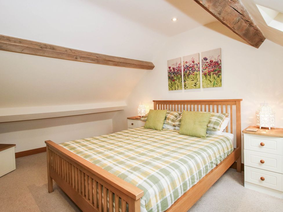 A bedroom with a bed and bedside tables at Swallows Cottage Harley near Much Wenlock