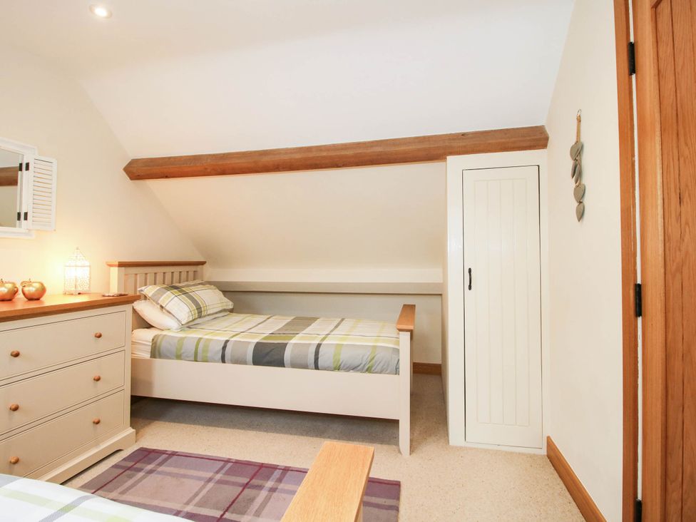 A bedroom with a bed and dresser at Swallows Cottage Harley near Much Wenlock
