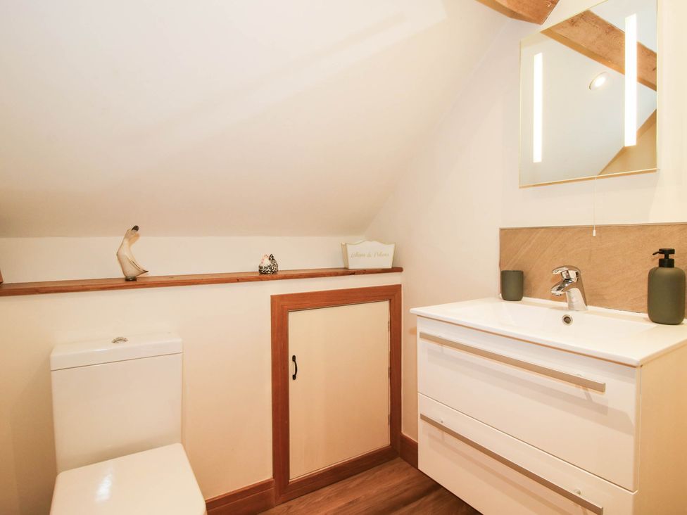A bathroom with a toilet and sink at Swallows Cottage in Harley near Much Wenlock