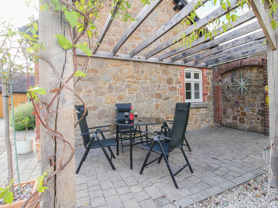 An outdoor seating area with a table and chairs at Swallows Cottage Harley near Much Wenlock