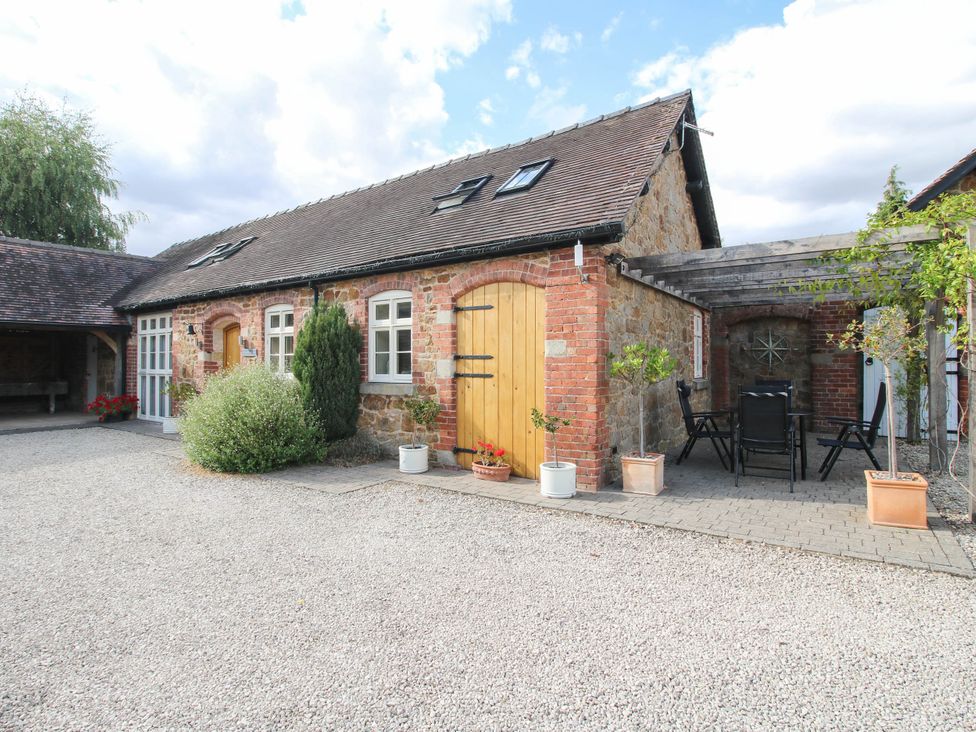 An outdoor area with a building, door, and seating at Swallows Cottage Harley near Much Wenlock