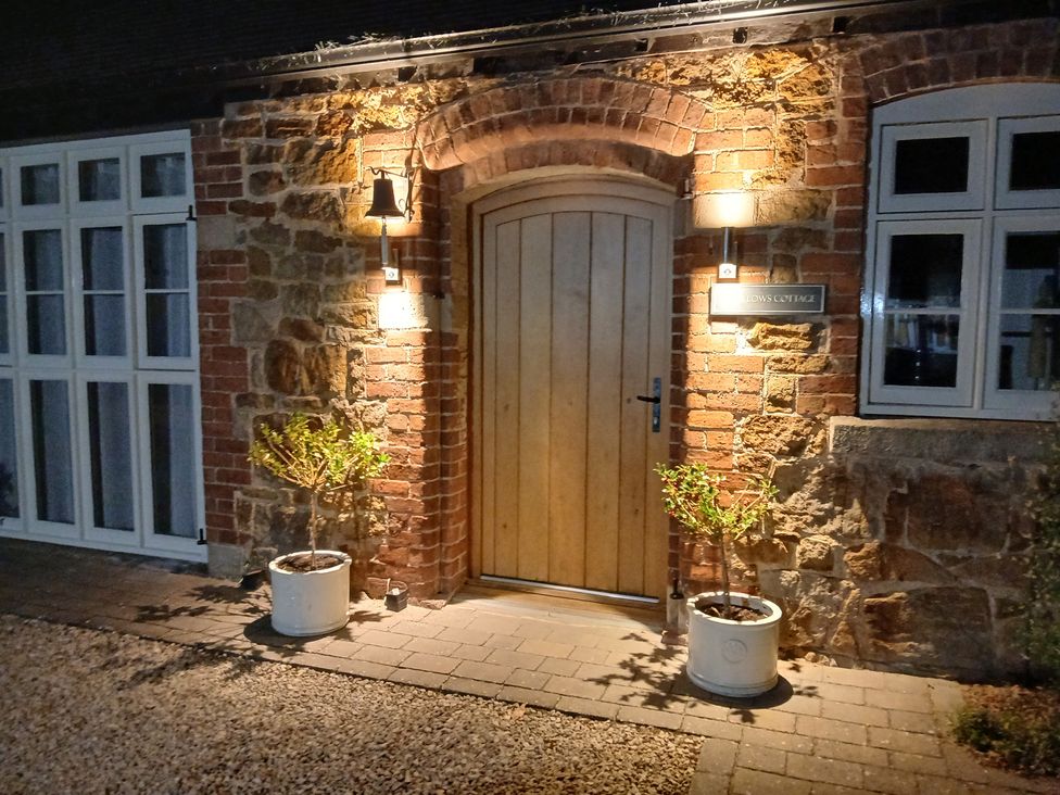 An entrance with a wooden door and plants at Swallows Cottage in Harley near Much Wenlock