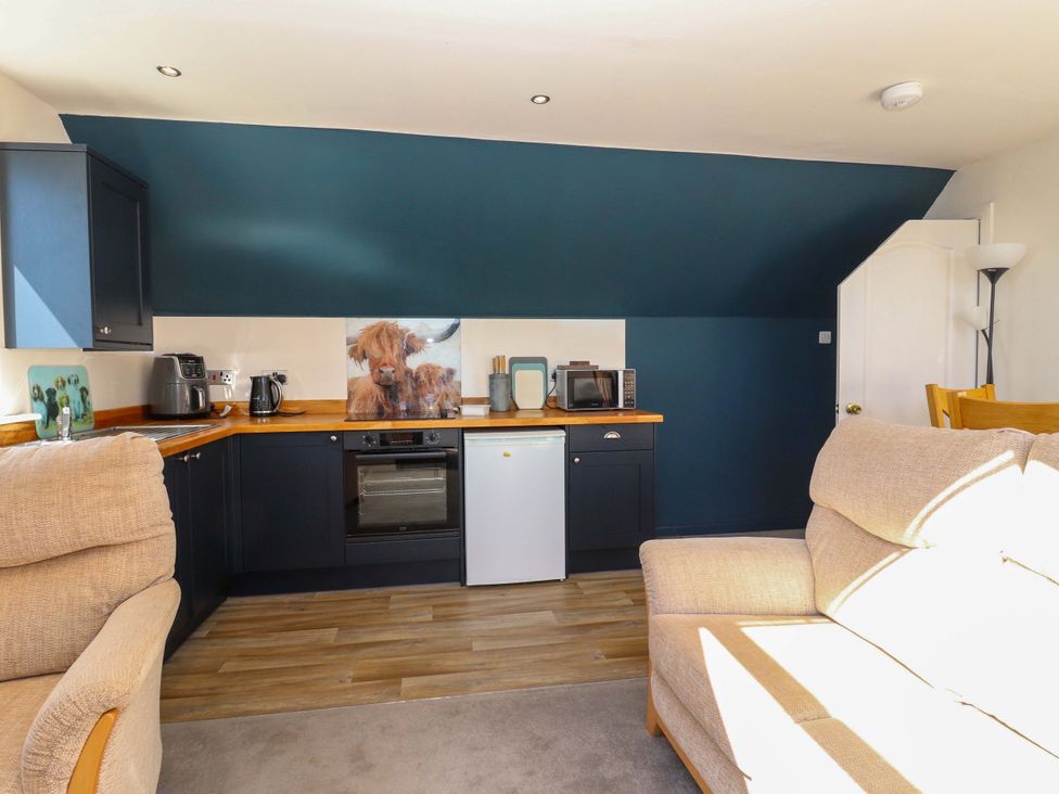 A kitchen with appliances and seating at Ceól na Mara, Uig
