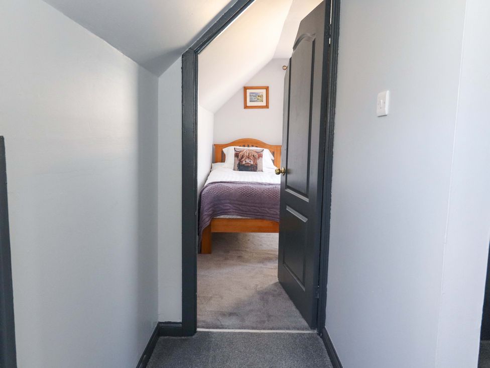 A bedroom with a bed and an open door at Ceól na Mara in Uig
